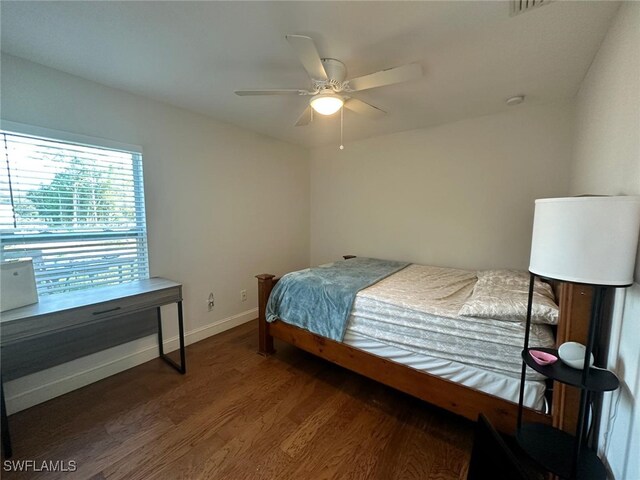 bedroom with a ceiling fan, wood finished floors, and baseboards