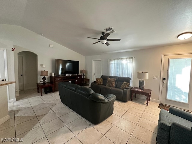 living room featuring arched walkways, visible vents, a healthy amount of sunlight, and light tile patterned flooring