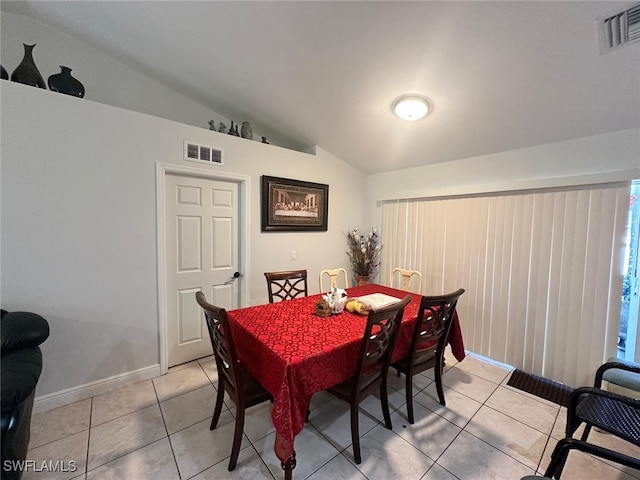 dining space with lofted ceiling, light tile patterned floors, baseboards, and visible vents