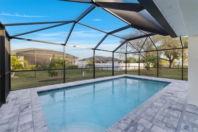 view of swimming pool with a patio area, glass enclosure, and a lawn