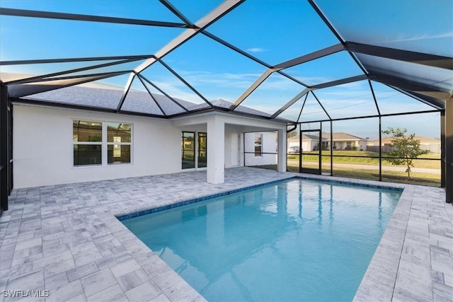 view of pool with a patio and glass enclosure