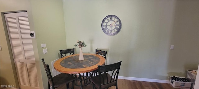 dining space with baseboards and wood finished floors