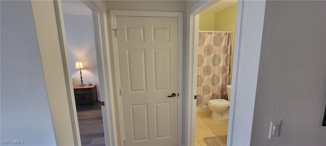 bathroom with walk in shower, tile patterned floors, and toilet