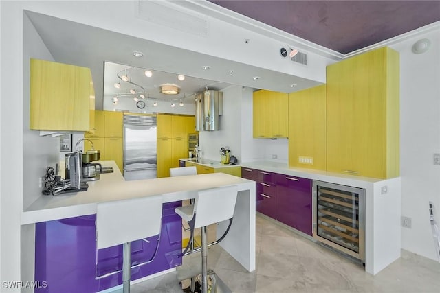 kitchen featuring wine cooler, stainless steel built in refrigerator, sink, a breakfast bar area, and kitchen peninsula