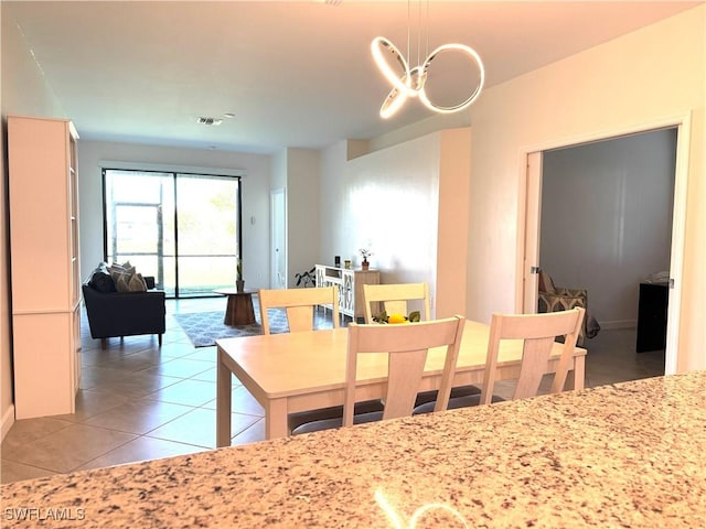 tiled dining room with a notable chandelier