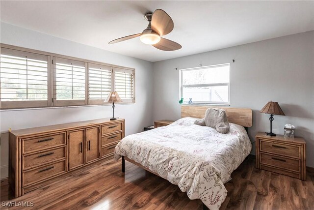 bedroom featuring dark wood-type flooring, ceiling fan, and multiple windows