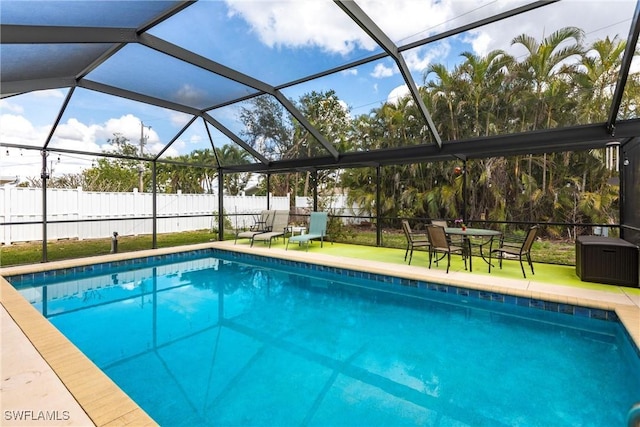 view of swimming pool featuring glass enclosure