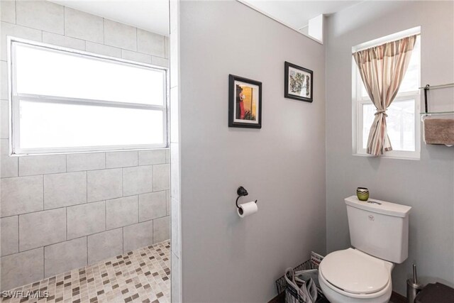 bathroom with tiled shower and toilet