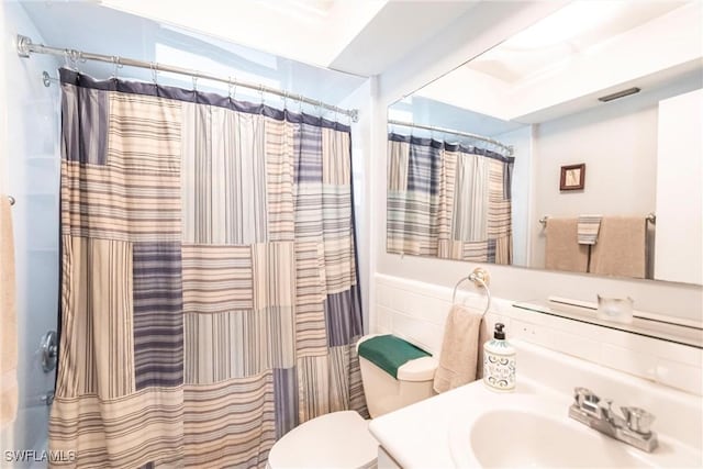 bathroom with vanity, a shower with shower curtain, and toilet