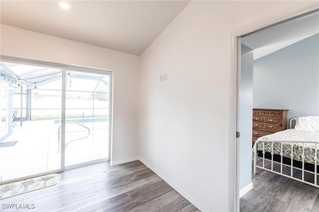 interior space featuring lofted ceiling, a sunroom, baseboards, and wood finished floors