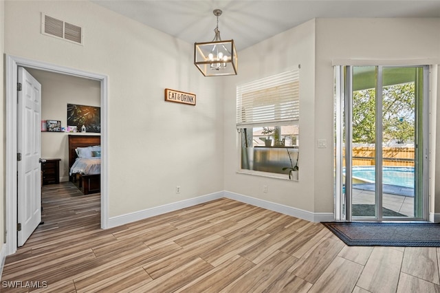 interior space featuring an inviting chandelier and light wood-type flooring