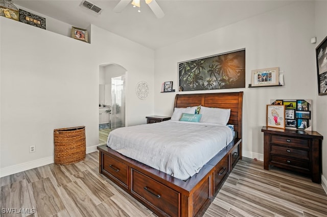 bedroom with ensuite bath, light hardwood / wood-style floors, and ceiling fan