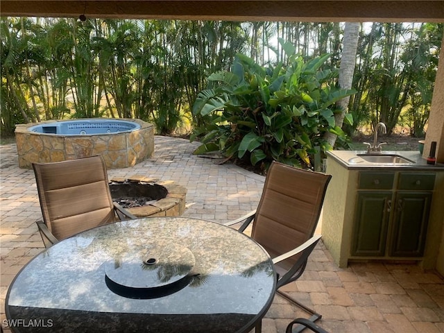 view of patio featuring an outdoor kitchen, sink, and an outdoor fire pit