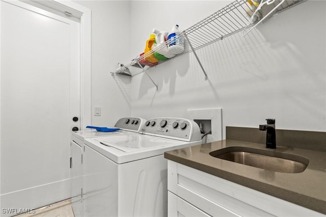 laundry room featuring sink, cabinets, and independent washer and dryer