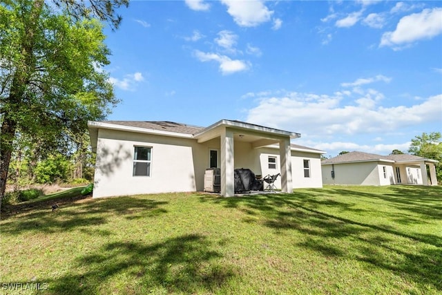 rear view of property featuring a lawn