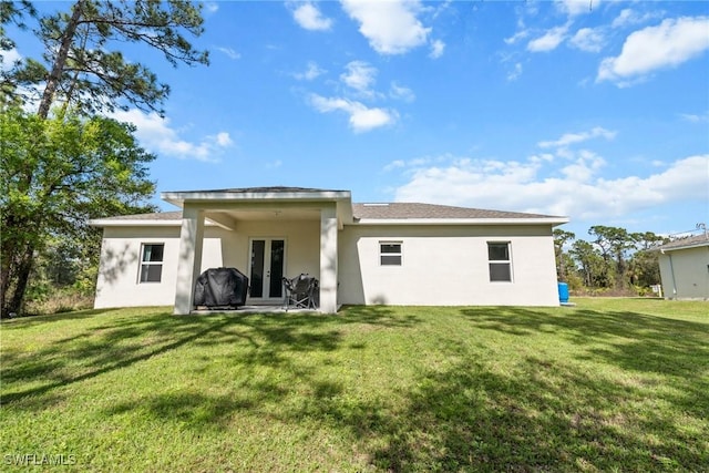 rear view of house featuring a yard and french doors