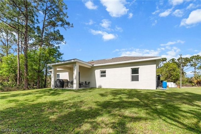 rear view of property with a yard and a patio