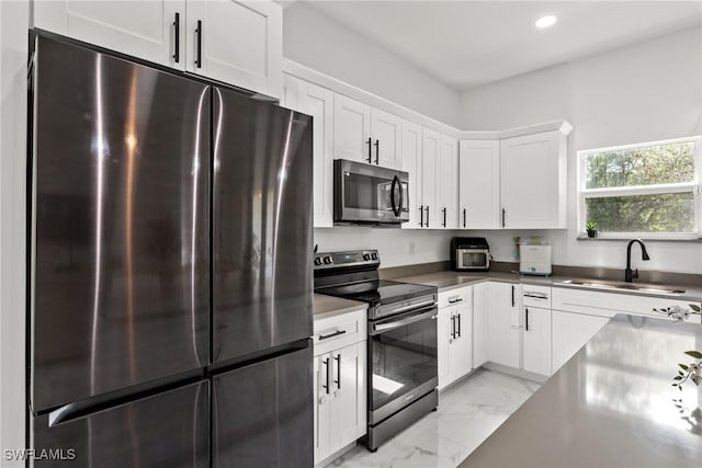 kitchen with white cabinetry, appliances with stainless steel finishes, and sink