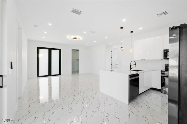 kitchen with appliances with stainless steel finishes, decorative light fixtures, sink, white cabinets, and kitchen peninsula