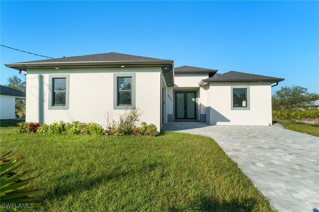 back of property featuring a lawn and french doors