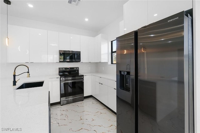 kitchen with pendant lighting, sink, stainless steel appliances, light stone countertops, and white cabinets