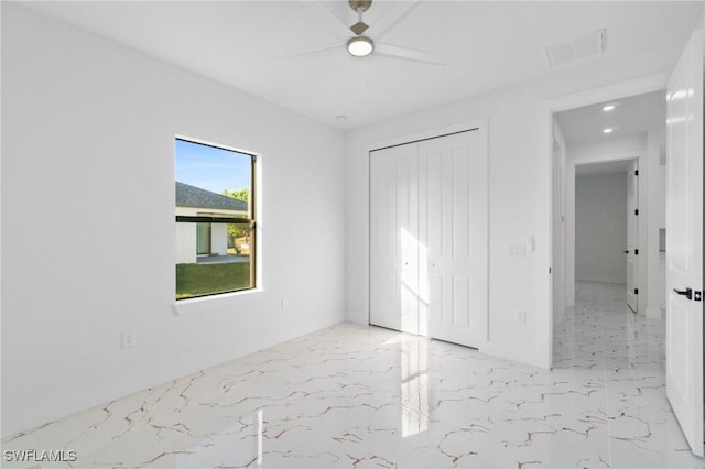 unfurnished bedroom featuring ceiling fan and a closet