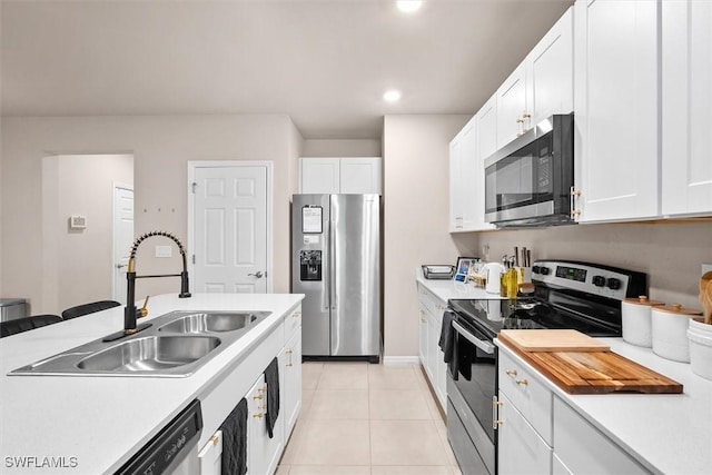 kitchen featuring white cabinetry, appliances with stainless steel finishes, sink, and light tile patterned floors