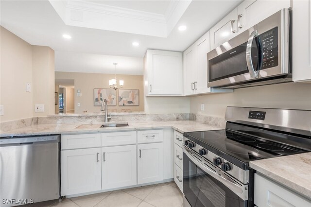 kitchen with appliances with stainless steel finishes, white cabinetry, sink, a tray ceiling, and crown molding