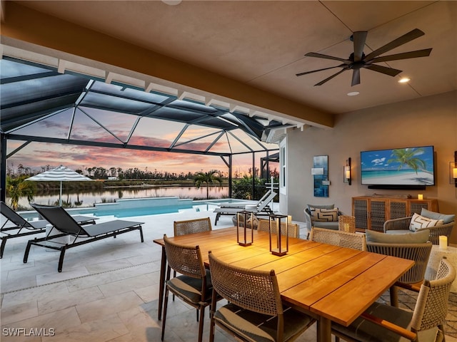 view of patio / terrace with a lanai, ceiling fan, outdoor lounge area, a water view, and a pool with hot tub