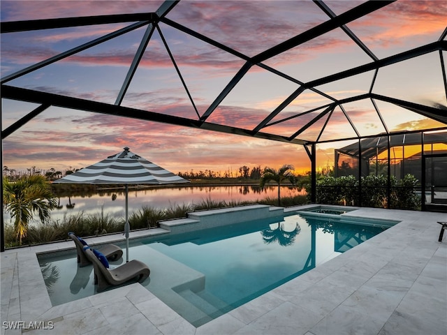 pool at dusk with a lanai, an in ground hot tub, a patio, and a water view