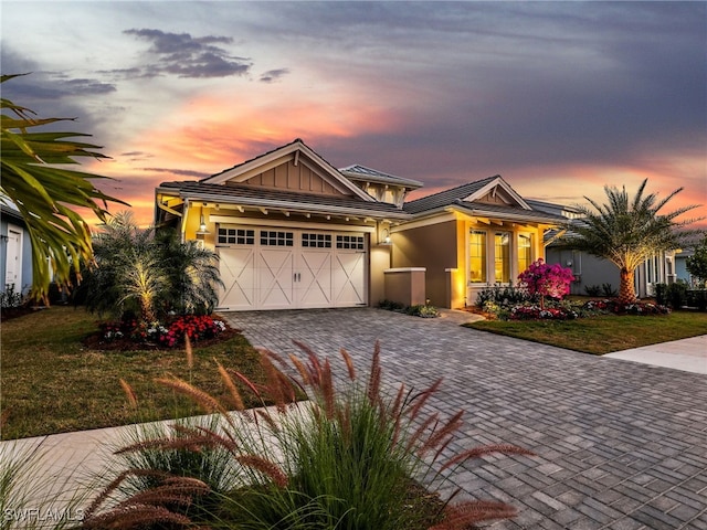 craftsman inspired home with a garage and a lawn