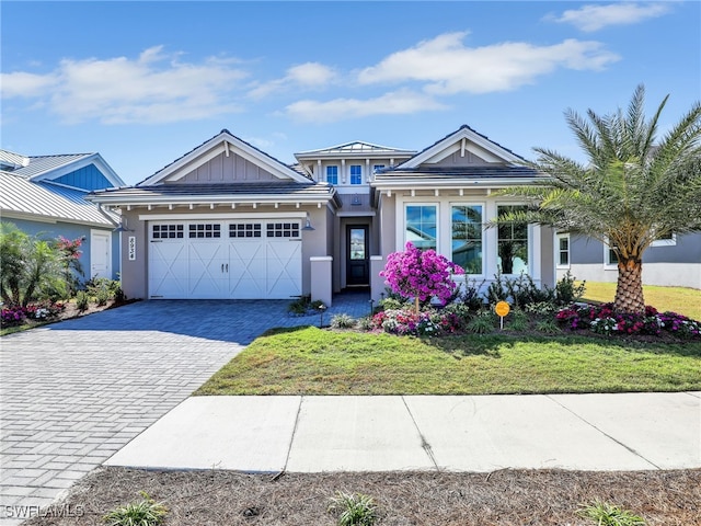 view of front of property with a garage and a front lawn