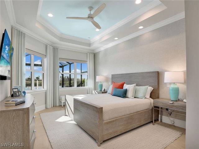 bedroom featuring ceiling fan, ornamental molding, and a raised ceiling