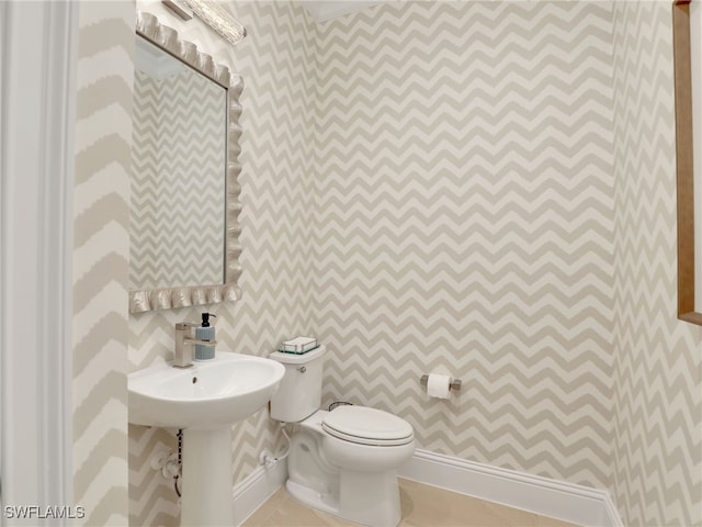 bathroom with toilet and tile patterned flooring