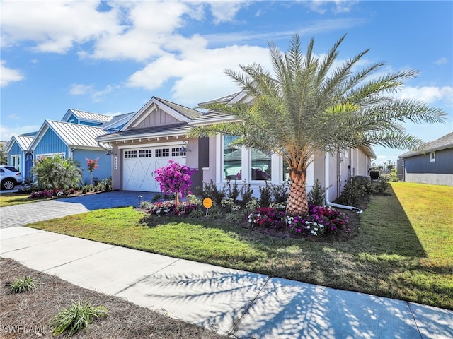 view of front of house featuring a garage and a front lawn