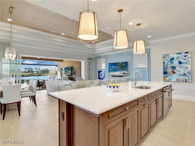 kitchen with sink, hanging light fixtures, dishwasher, a raised ceiling, and a kitchen island with sink