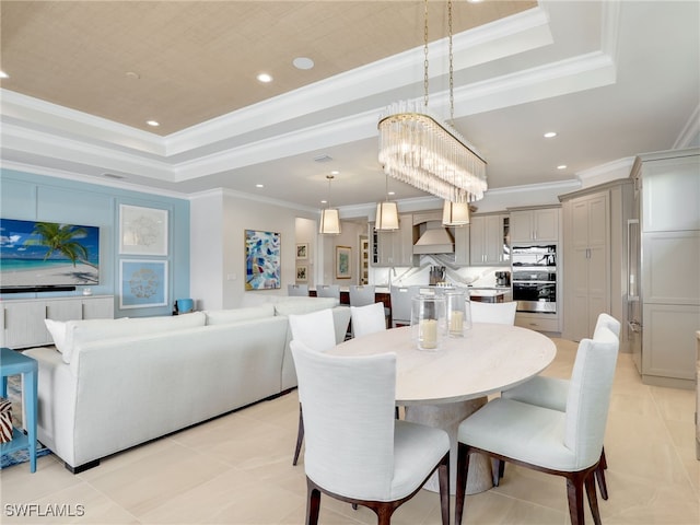 tiled dining area featuring crown molding and a tray ceiling