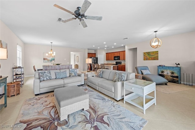 living room featuring light tile patterned floors and ceiling fan with notable chandelier