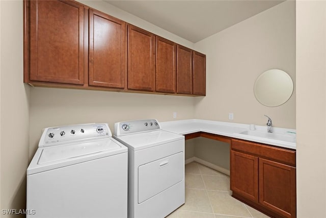 laundry area featuring cabinets, sink, washing machine and dryer, and light tile patterned floors