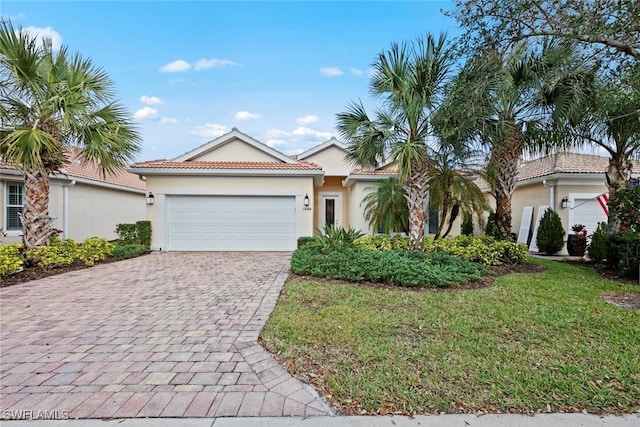 mediterranean / spanish-style house with a garage and a front lawn