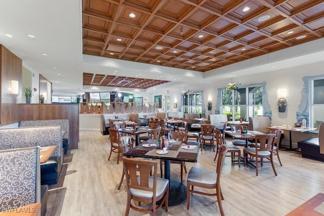 dining space featuring coffered ceiling and light hardwood / wood-style floors