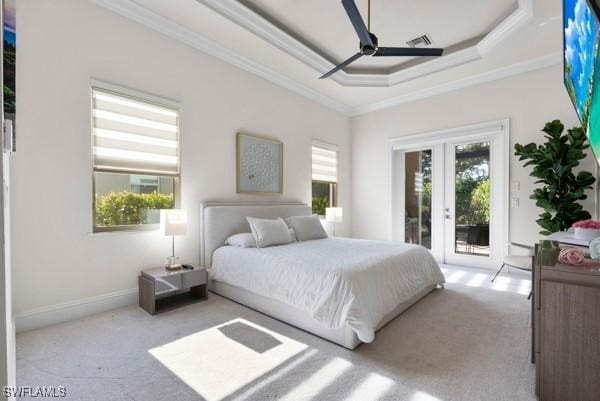 carpeted bedroom featuring crown molding, ceiling fan, access to exterior, a tray ceiling, and french doors