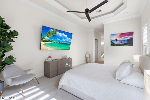 carpeted bedroom with crown molding, ceiling fan, and a tray ceiling