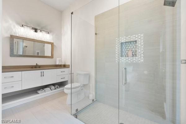 bathroom with vanity, tile patterned flooring, a shower with shower door, and toilet