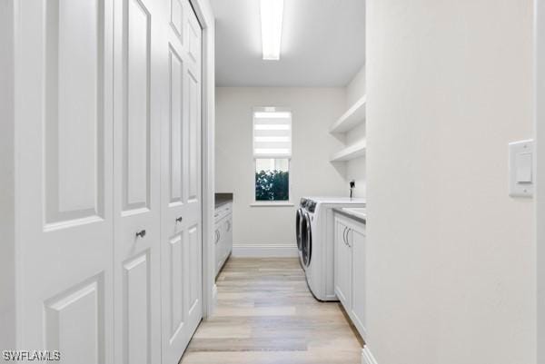 washroom with cabinets, light wood-type flooring, and independent washer and dryer