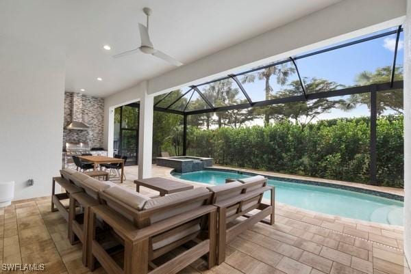 view of pool with an outdoor kitchen, a lanai, an in ground hot tub, ceiling fan, and a patio