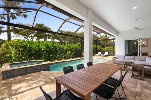 view of pool with an in ground hot tub, an outdoor living space, a lanai, and a patio