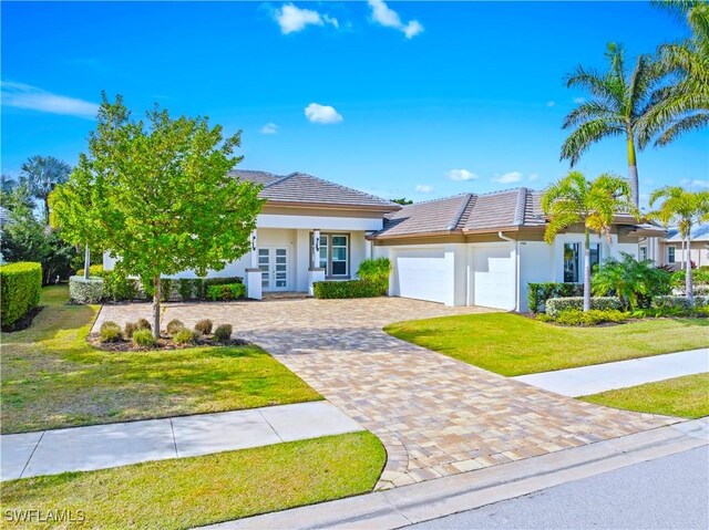 14362 Charthouse Cir, Naples, FL 34114 - view of front of house with stucco siding, a garage, french doors, and a front yard