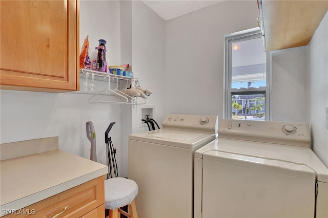 washroom with cabinets and washer and dryer