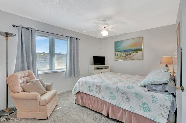 carpeted bedroom with ceiling fan and a textured ceiling